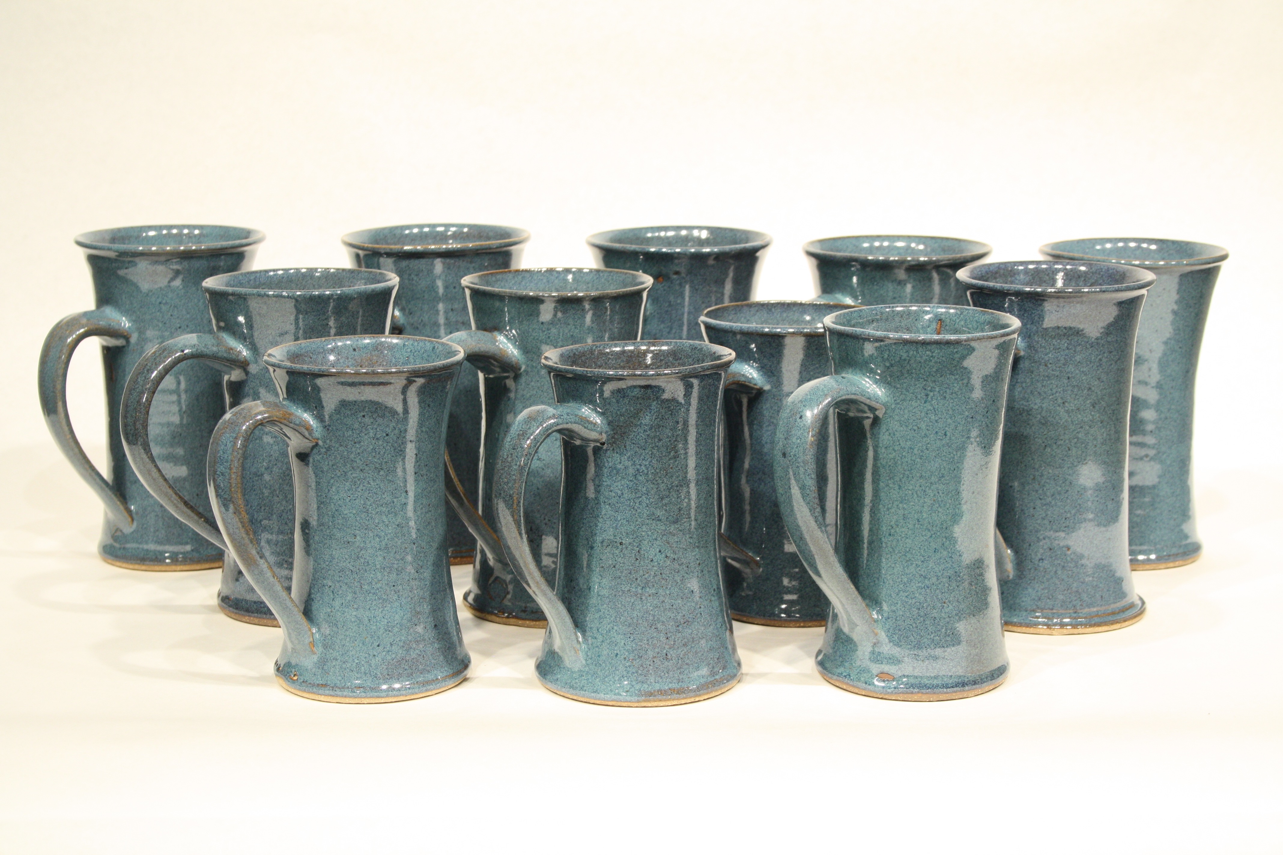 12 of a series of 150 turquoise glazed ceramic mugs