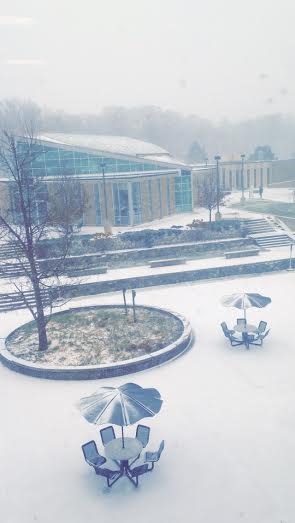 A bright photograph of the college's quad filled with snow