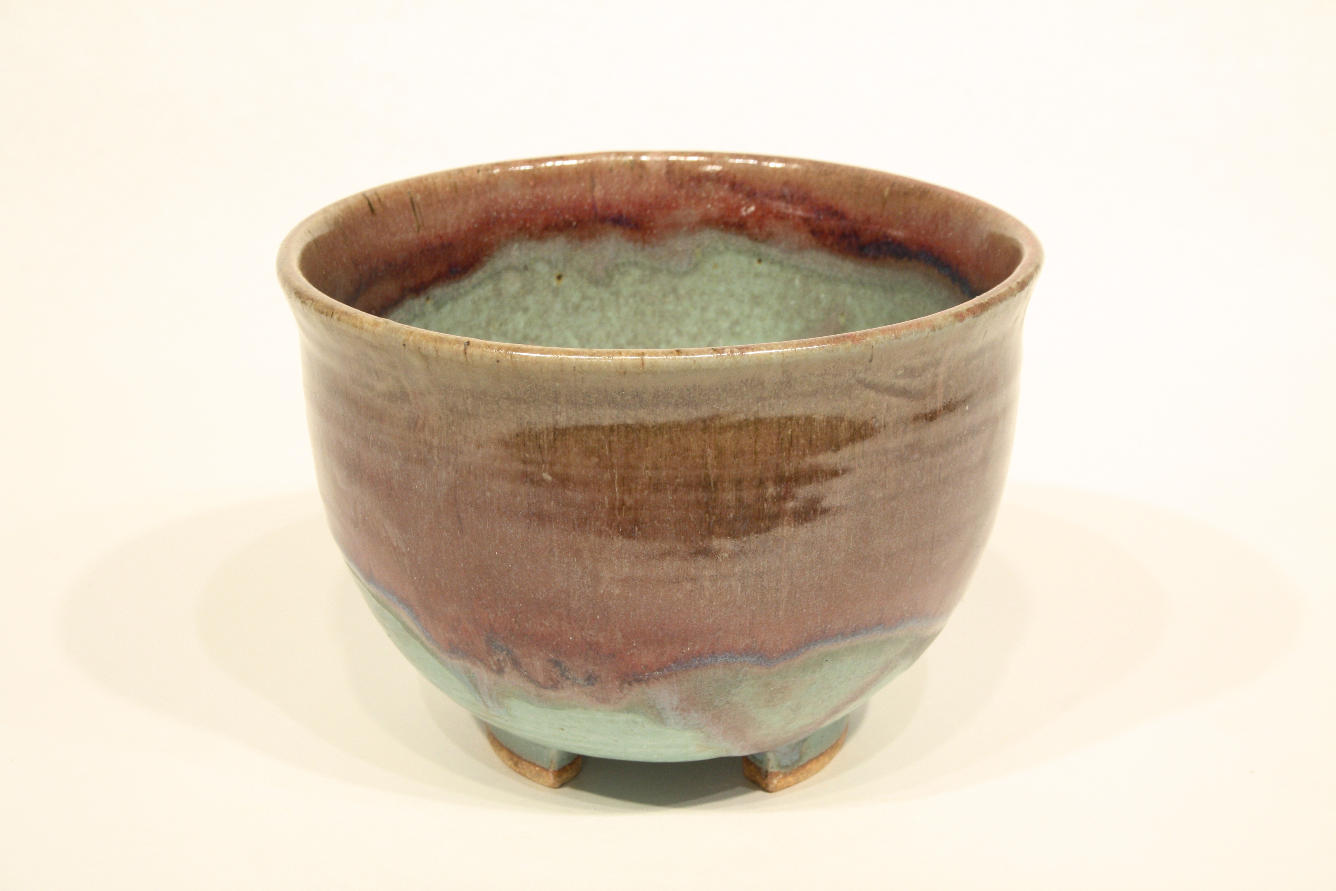 Elegant ceramic bowl with green and brown colors merging together.