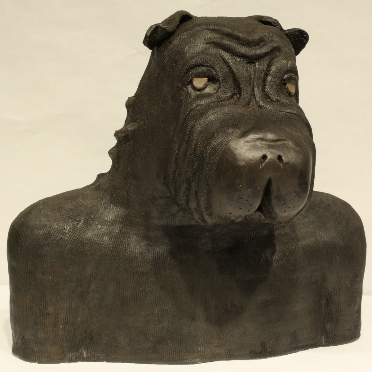 Sculpture of a male bust with a dog head.