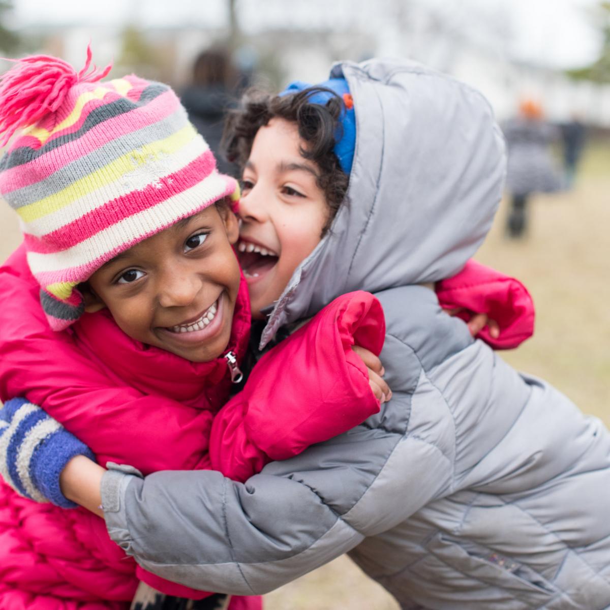 Two children hugging during outdoor recess at Charlotte Mason School in Detroit courtesy Field-Gems-Photography-Detroit-Michigan-Wedding-Photographer-Family-Photographer