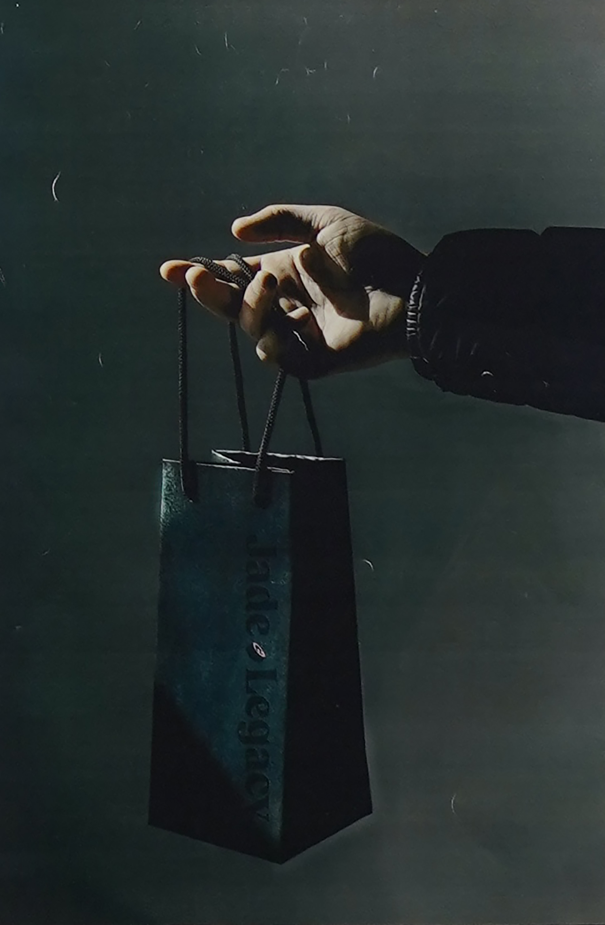 Artistic photograph of a hand holding a gift bag by Chase Lett