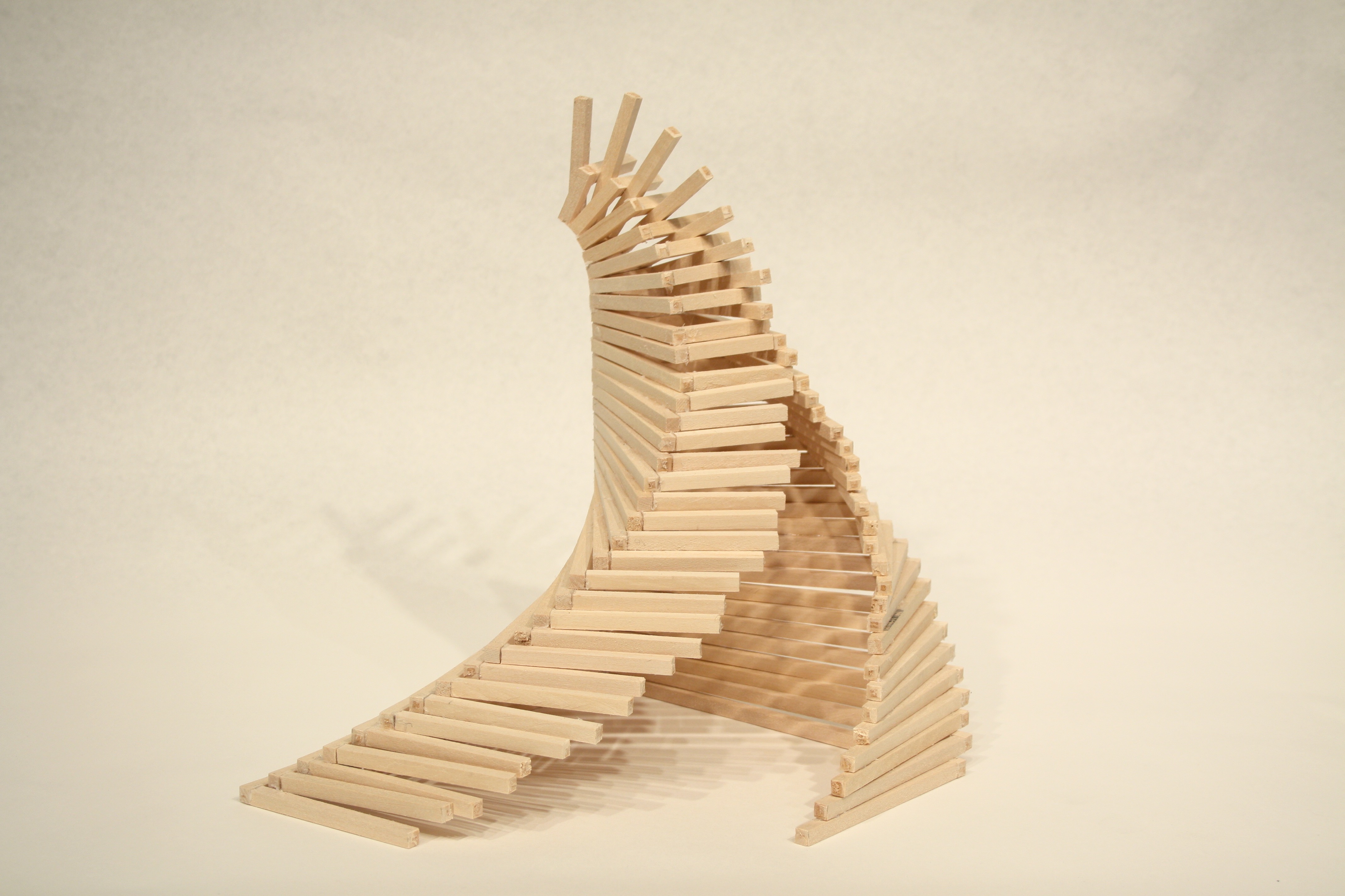 Wooden sticks piled together to form a curving tower with a split opening.